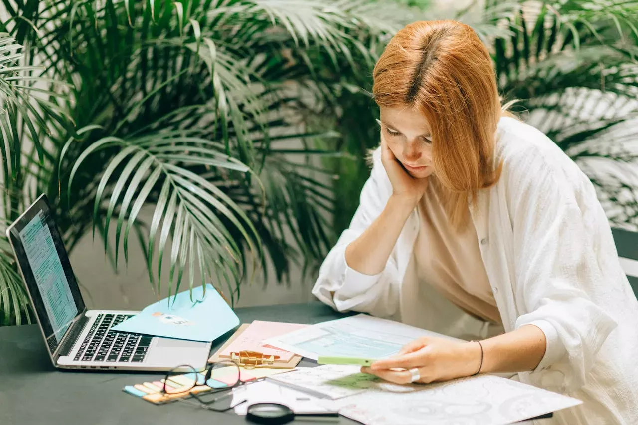 Woman reviewing mortgage documents and financial paperwork with a concerned expression.