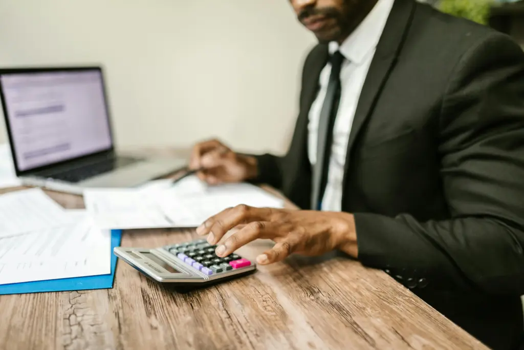 Adviser reviewing mortgage income documents with a calculator.