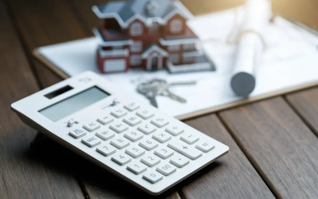 Calculator, keys and house model used to review remortgage costs.
