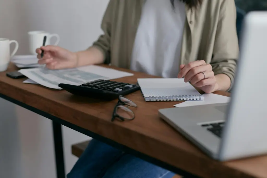 Person using a calculator to review figures before a remortgage valuation.