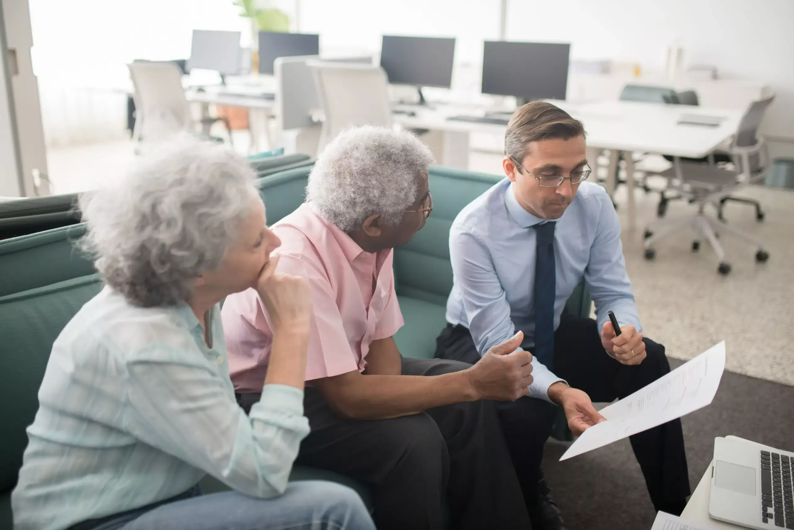 Older couple discussing mortgage documents with a financial adviser.