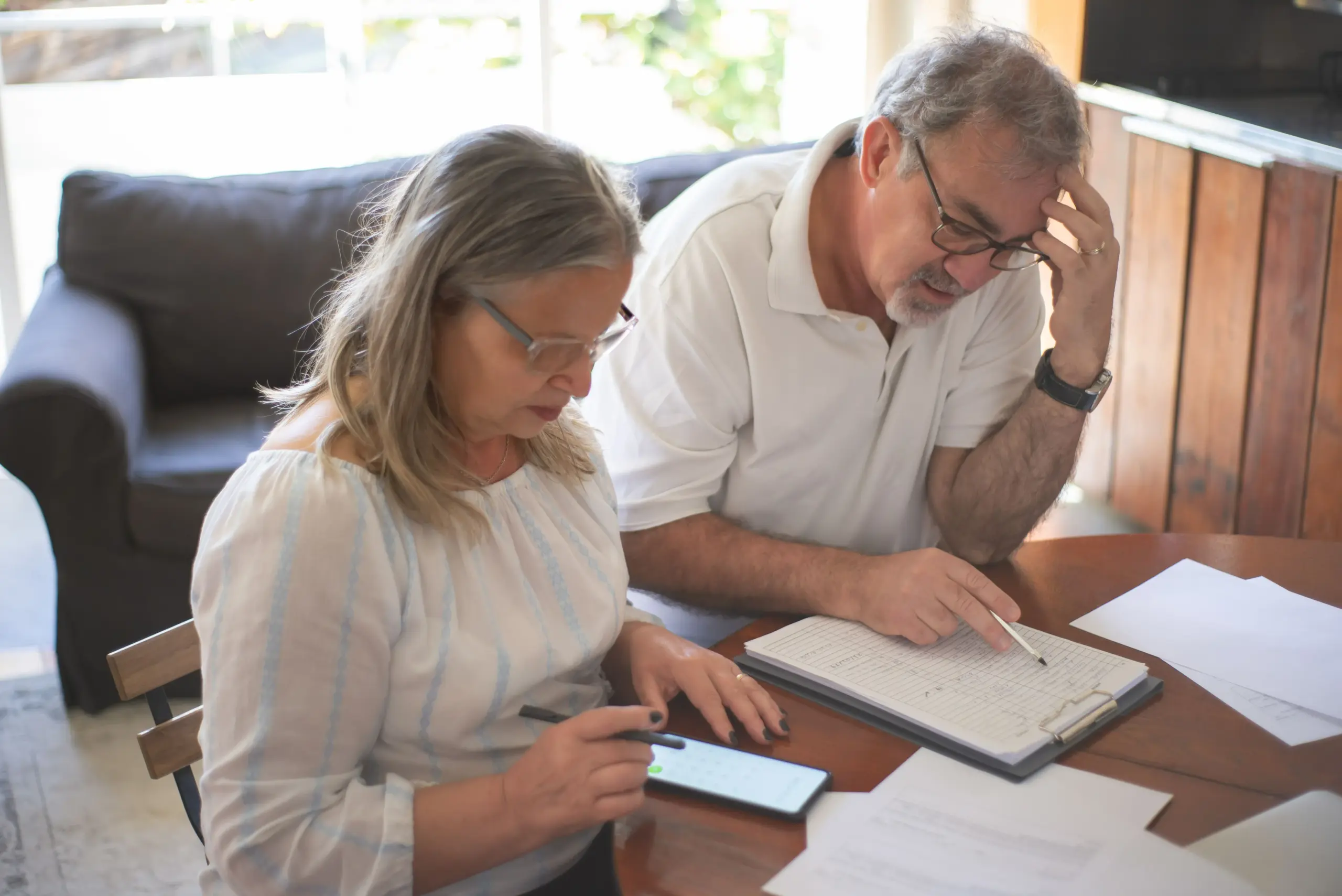 Senior couple reviewing financial records while planning for retirement.
